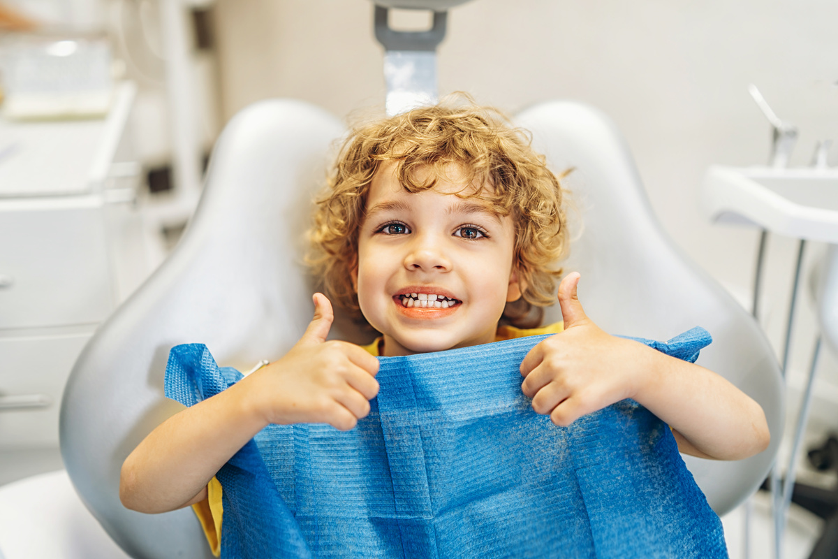 Cute Little Boy Showing Thumbs Up at the Dental Clinic